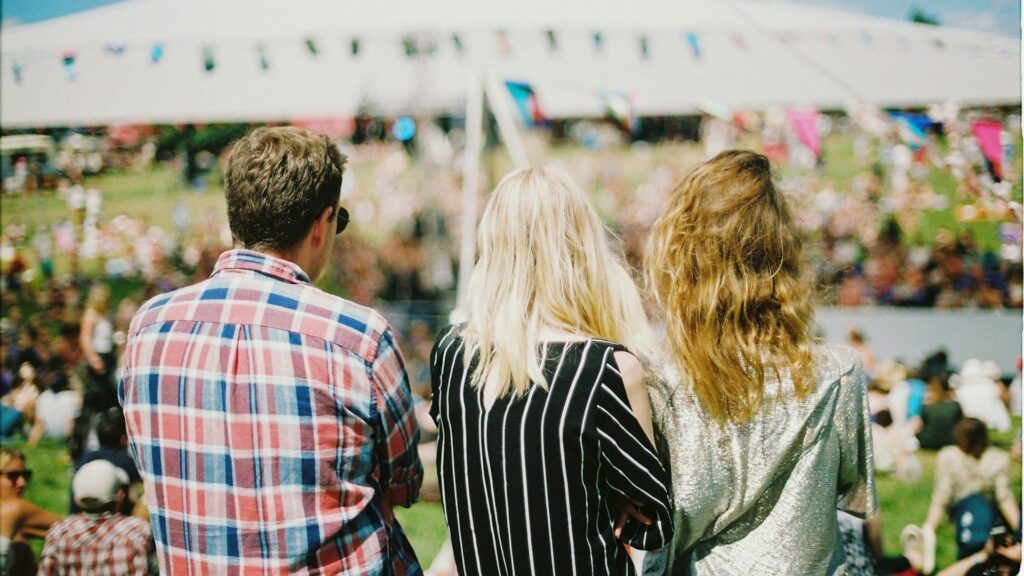 Bezoekers genieten van een zonnig festival met creatieve, budgetvriendelijke evenementen aankleding.

